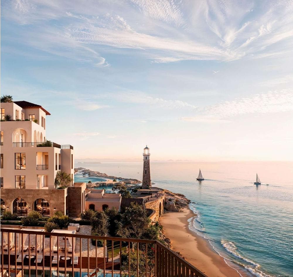 Apartments above the beach with a lighthouse and sailboats